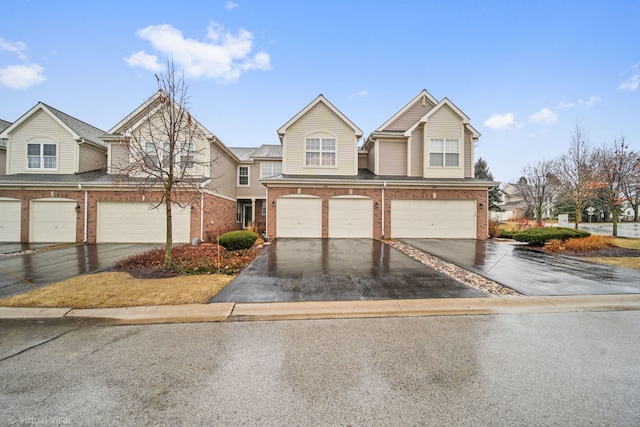 townhome / multi-family property featuring brick siding and driveway