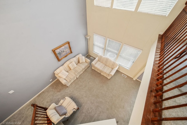 unfurnished living room featuring a wealth of natural light, carpet flooring, and visible vents