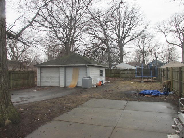 detached garage featuring a trampoline and fence