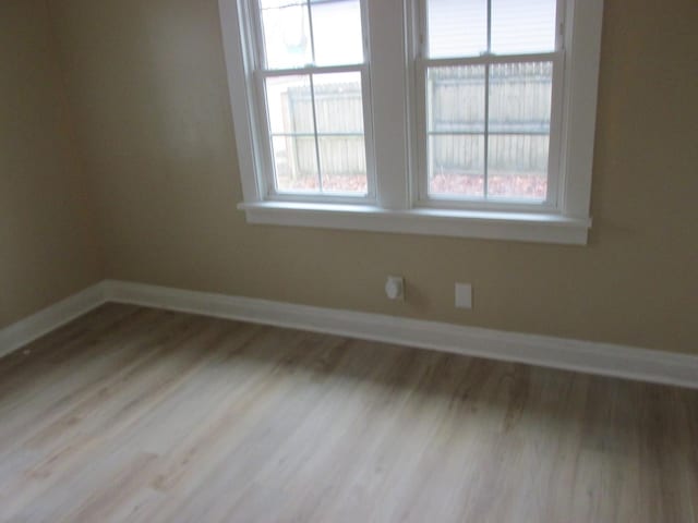 unfurnished room with wood finished floors and baseboards