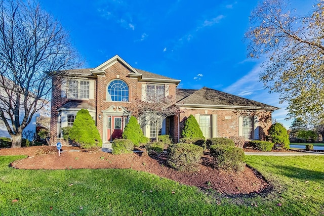 view of front of house with brick siding and a front yard