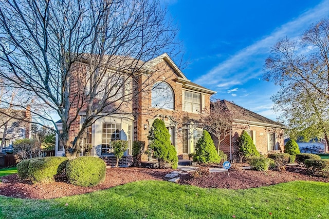 view of front of property with brick siding and a front lawn