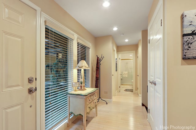 corridor featuring light wood-type flooring, baseboards, and recessed lighting