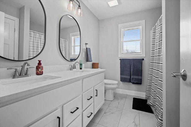 full bath with a sink, marble finish floor, and a healthy amount of sunlight