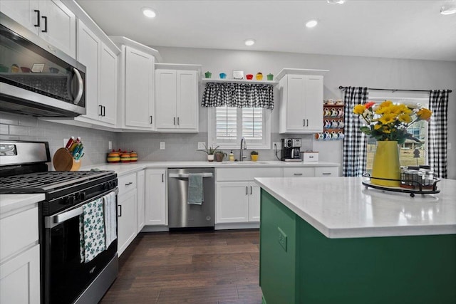 kitchen featuring white cabinetry, backsplash, appliances with stainless steel finishes, and a sink