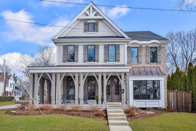 view of front of property featuring a front lawn, a standing seam roof, fence, french doors, and metal roof