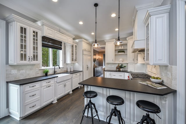 kitchen with open shelves, dark countertops, a peninsula, and white cabinets