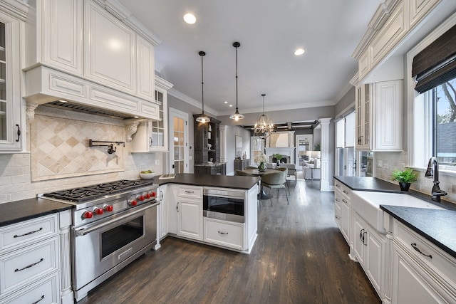 kitchen with luxury range, a sink, dark countertops, a peninsula, and built in microwave