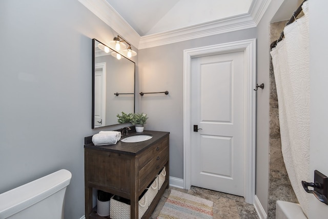 bathroom featuring vanity, baseboards, vaulted ceiling, crown molding, and toilet