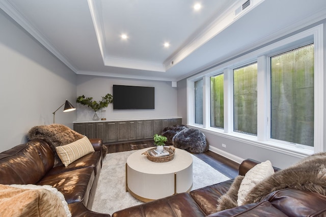 living area featuring visible vents, ornamental molding, wood finished floors, baseboards, and a raised ceiling