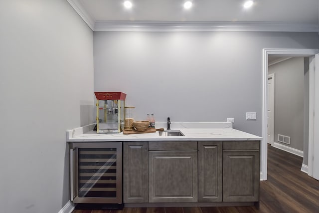 bar with beverage cooler, visible vents, dark wood-type flooring, bar, and crown molding