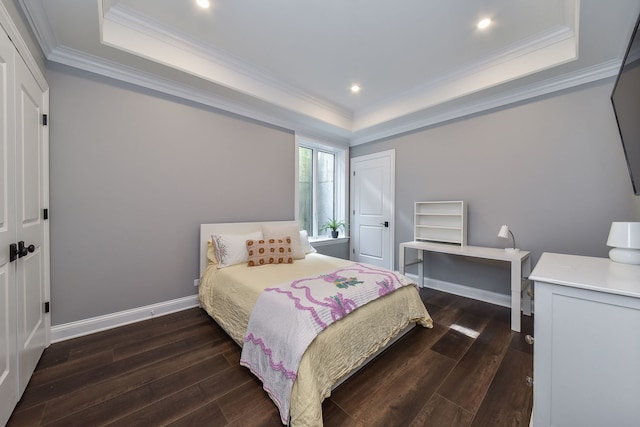 bedroom with baseboards, a raised ceiling, dark wood finished floors, and crown molding