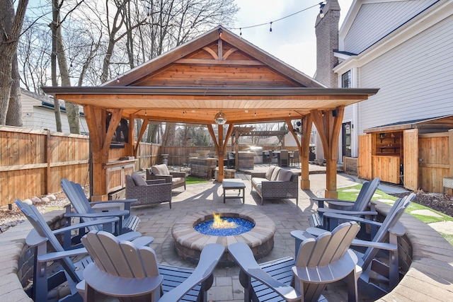 view of patio with an outdoor living space with a fire pit, a gazebo, and a fenced backyard