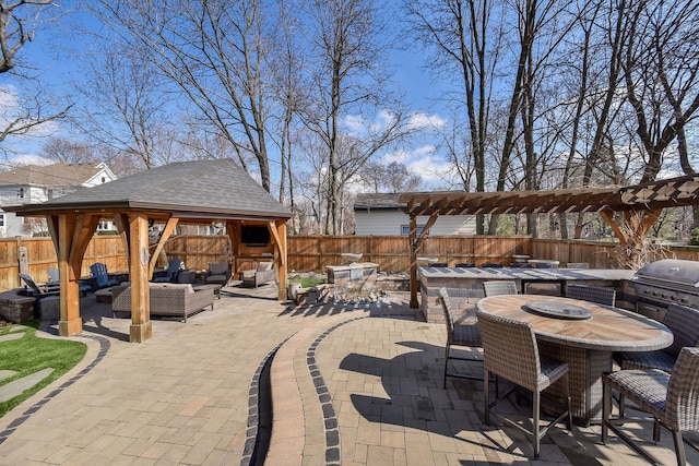 view of patio featuring outdoor dining space, a fenced backyard, a gazebo, grilling area, and an outdoor living space with a fire pit