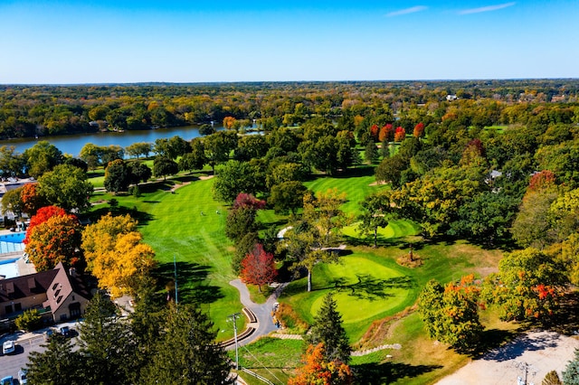 birds eye view of property with a water view, a wooded view, and golf course view