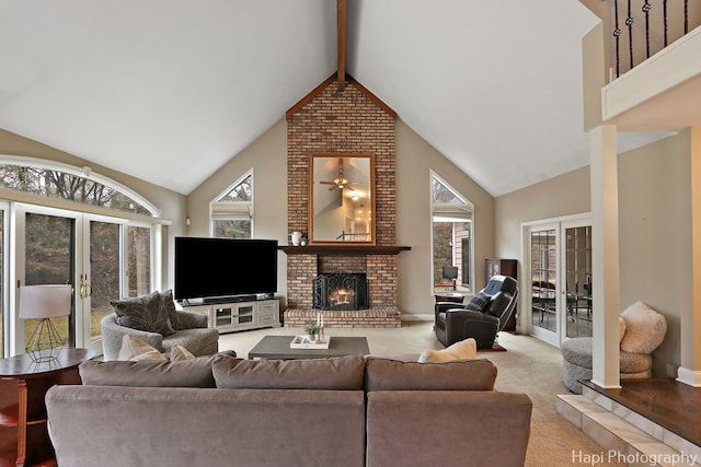 carpeted living room with beam ceiling, high vaulted ceiling, french doors, and a fireplace