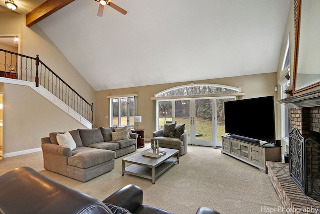 carpeted living room with a brick fireplace, stairs, beam ceiling, high vaulted ceiling, and a ceiling fan