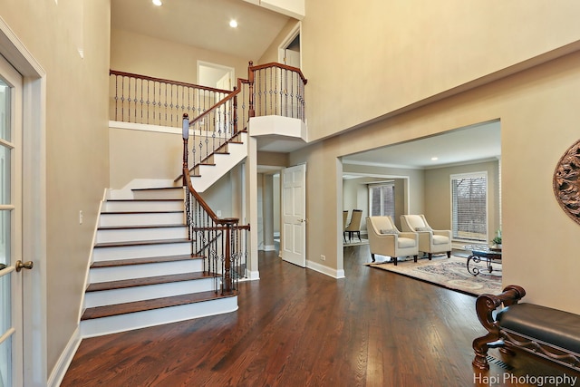 foyer entrance featuring wood finished floors, recessed lighting, a high ceiling, baseboards, and stairs