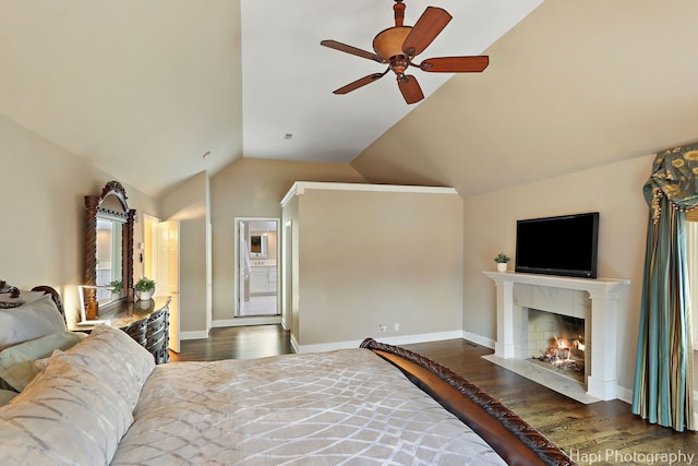 bedroom with lofted ceiling, a fireplace with flush hearth, wood finished floors, and baseboards