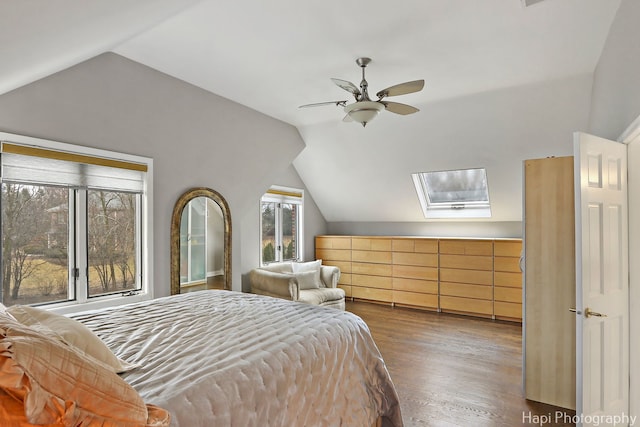 bedroom with a ceiling fan, lofted ceiling, and wood finished floors