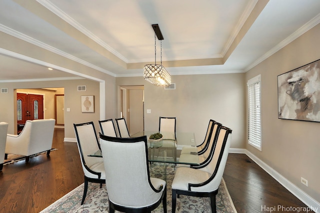 dining space featuring dark wood-style floors, visible vents, and a raised ceiling