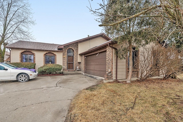 single story home featuring brick siding, an attached garage, and driveway