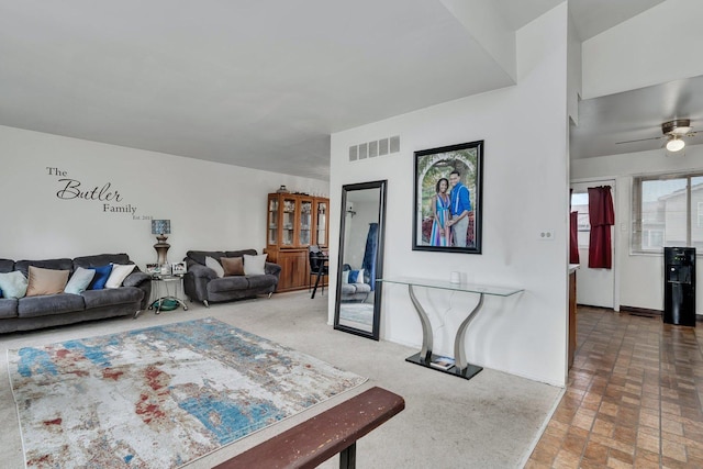 living room featuring baseboards, visible vents, and ceiling fan