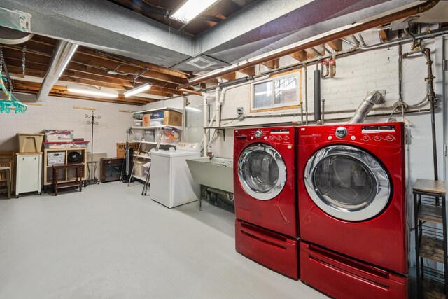 laundry area featuring laundry area, a sink, and washing machine and clothes dryer