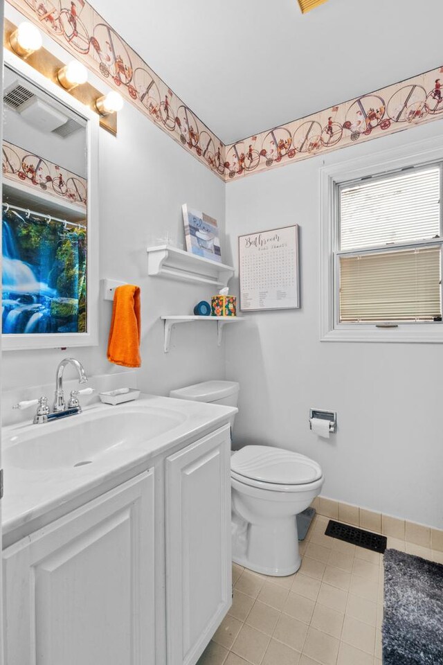 bathroom with tile patterned flooring, toilet, visible vents, vanity, and baseboards