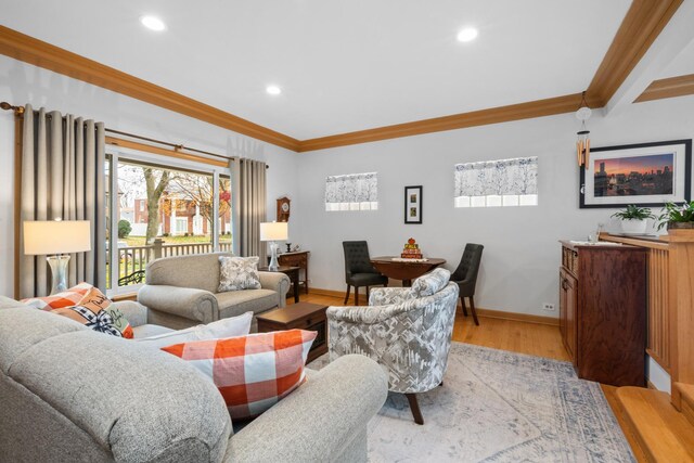 living room featuring light wood-style flooring, ornamental molding, baseboards, and recessed lighting