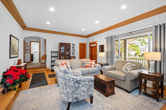 living room featuring arched walkways, crown molding, recessed lighting, and light wood-style floors