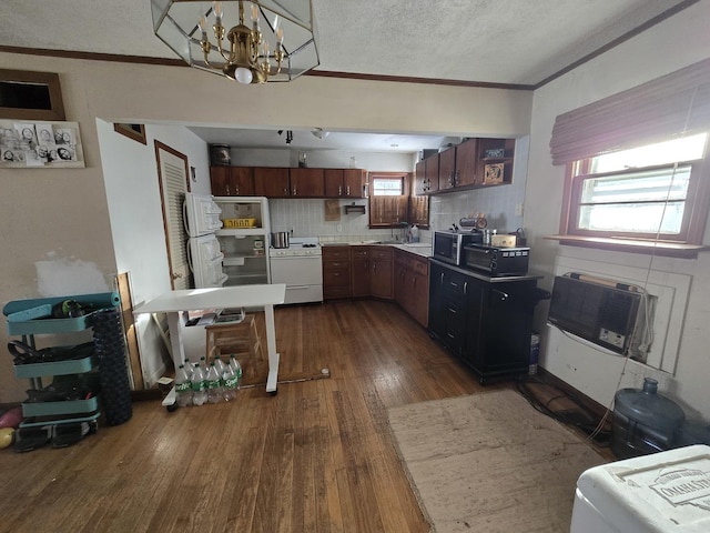 kitchen with dark wood-style floors, crown molding, stainless steel microwave, and white range with gas stovetop