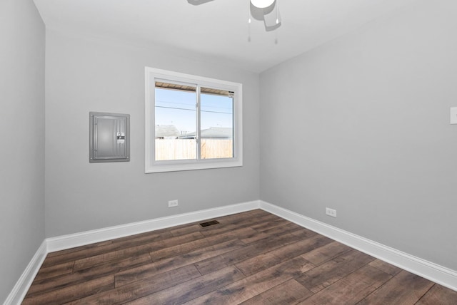 empty room with a ceiling fan, visible vents, baseboards, electric panel, and dark wood finished floors