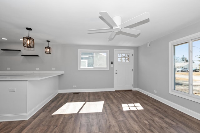 foyer entrance with baseboards, a wealth of natural light, and wood finished floors