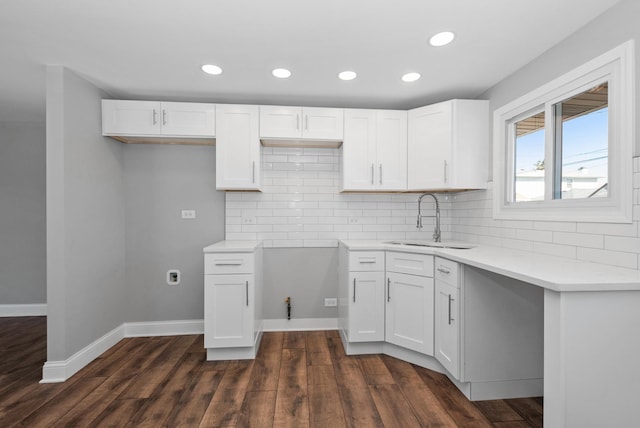 kitchen with backsplash, white cabinetry, dark wood finished floors, and a sink