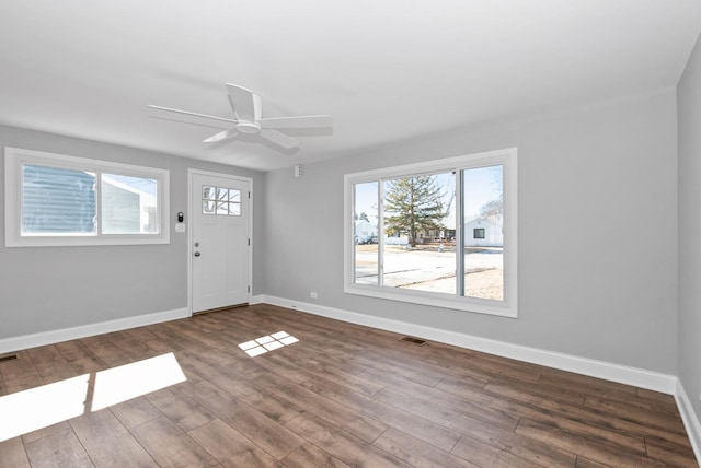 foyer entrance with wood finished floors, visible vents, and baseboards