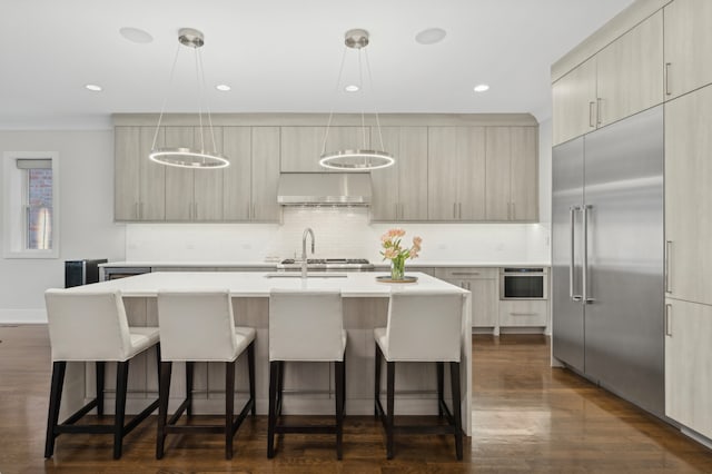 kitchen featuring tasteful backsplash, appliances with stainless steel finishes, wall chimney exhaust hood, and light countertops