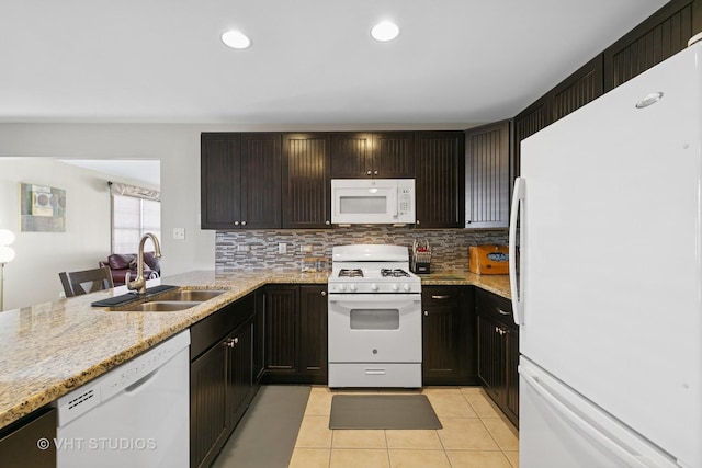 kitchen with light tile patterned floors, white appliances, a sink, and decorative backsplash