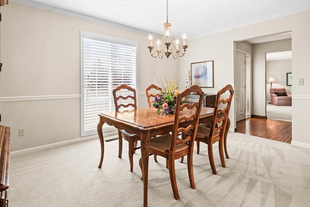 dining area featuring baseboards, light carpet, an inviting chandelier, and ornamental molding