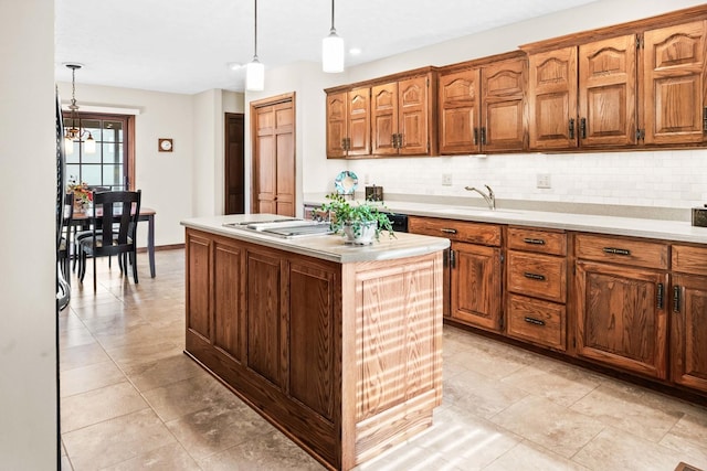 kitchen with brown cabinetry, light countertops, decorative light fixtures, backsplash, and a center island