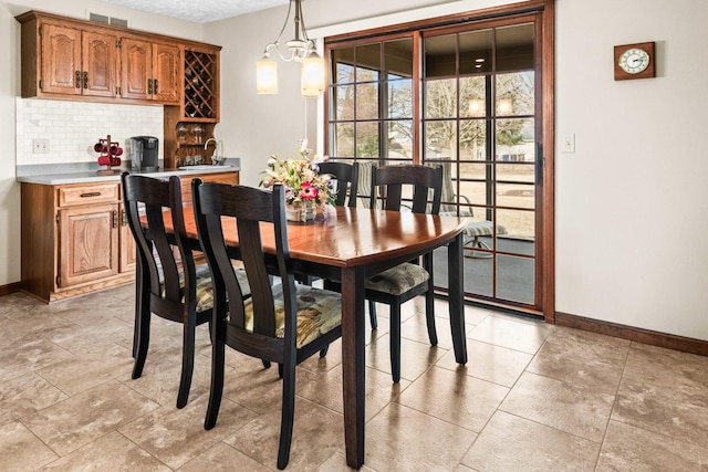 dining space with visible vents, baseboards, and a notable chandelier