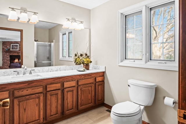 full bath featuring plenty of natural light, toilet, a fireplace, and a shower stall