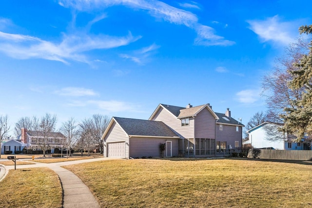 view of side of home featuring a lawn, fence, an attached garage, a sunroom, and a chimney