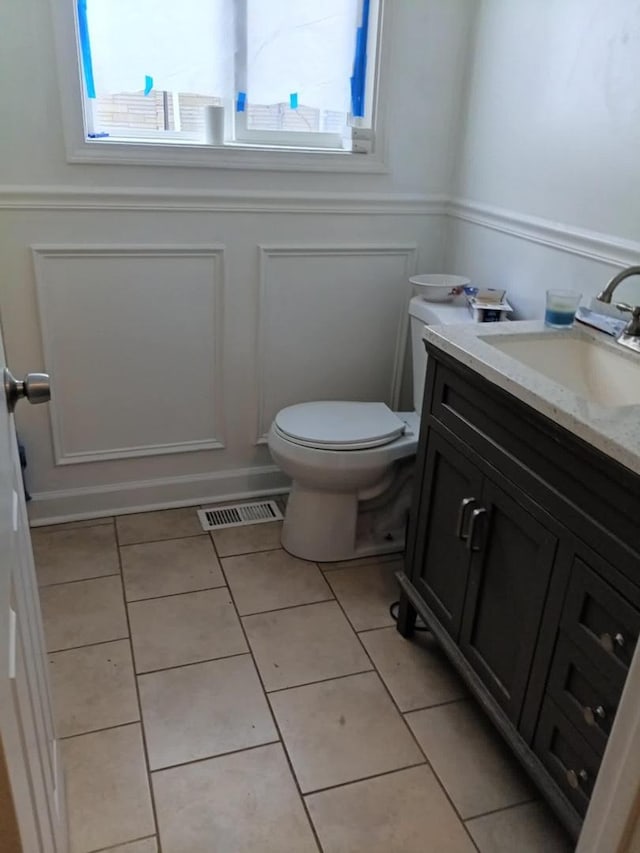 5348 S Peoria St, Chicago, IL 60609 - bathroom featuring plenty of natural light, tile patterned floors, vanity, a decorative wall, and wainscoting