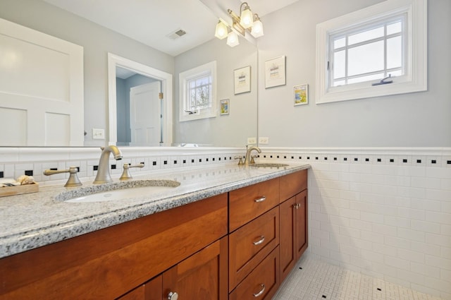 384 Provident Ave, Winnetka, IL 60093 - full bath with tile walls, double vanity, tile patterned flooring, and a wainscoted wall