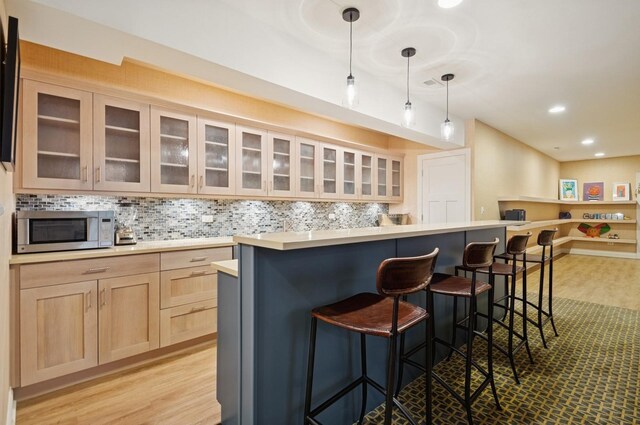 384 Provident Ave, Winnetka, IL 60093 - bar area with stainless steel microwave, light wood finished floors, tasteful backsplash, recessed lighting, and pendant lighting