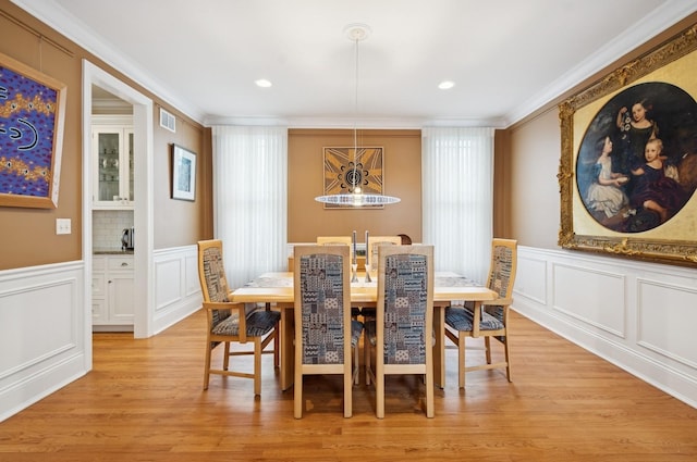 384 Provident Ave, Winnetka, IL 60093 - dining room featuring a decorative wall, crown molding, light wood finished floors, a wainscoted wall, and a chandelier