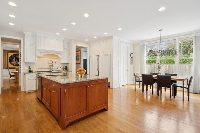 384 Provident Ave, Winnetka, IL 60093 - kitchen featuring a sink, tasteful backsplash, light wood-style flooring, custom range hood, and light stone counters