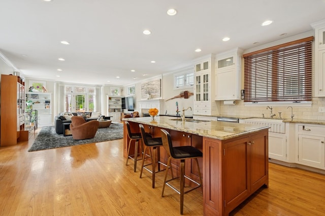 384 Provident Ave, Winnetka, IL 60093 - kitchen with a sink, a kitchen island with sink, open floor plan, tasteful backsplash, and crown molding