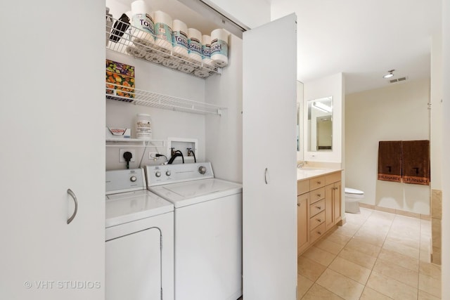 washroom with laundry area, light tile patterned floors, visible vents, independent washer and dryer, and a sink